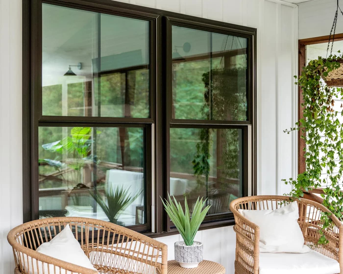 Window in front of white home with dark frames.